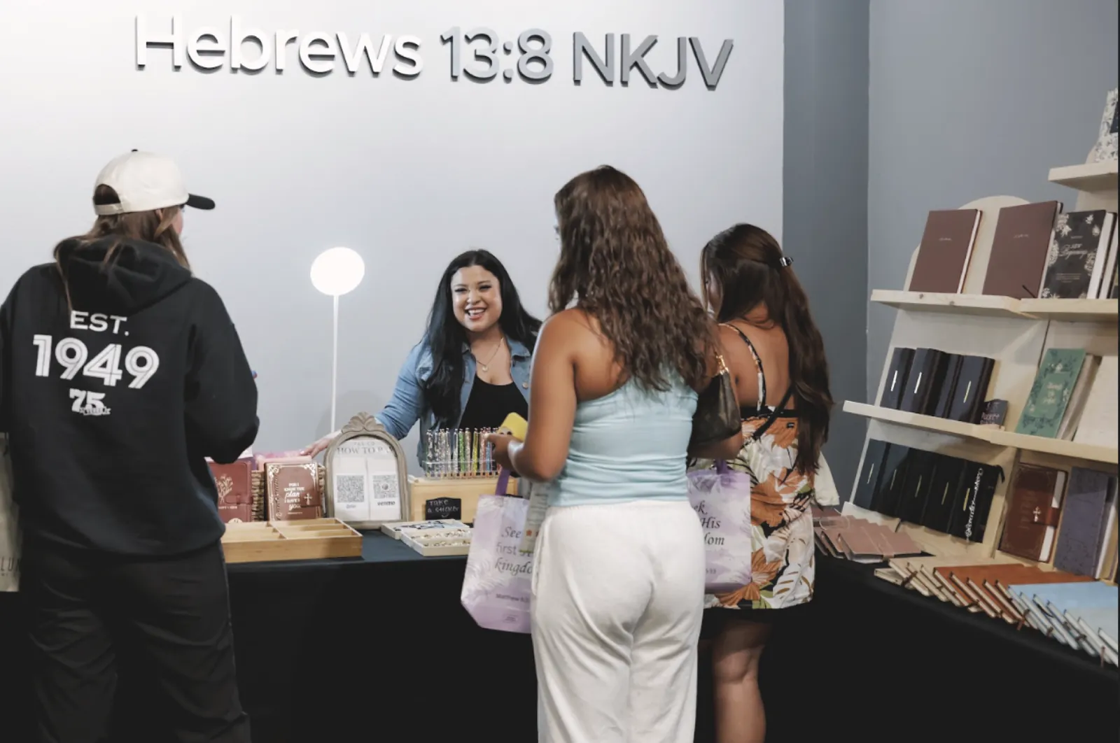 Shoppers visiting a faith-based book and journal booth at the A Company of Women market